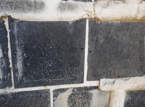 Particolare di muro di kura in cui il namako si è rotto mostrando i buchi dei perni che fissano le piastrelle