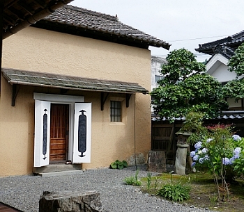 kura in terra con porta intonacata e giardino a Katsuyama