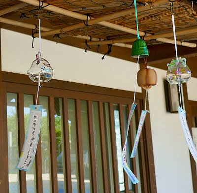 Campanelle di vetro e metallo con striscia di carta appesa al battacchio