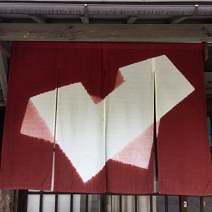 noren disegno geometrico a sfondo mattone