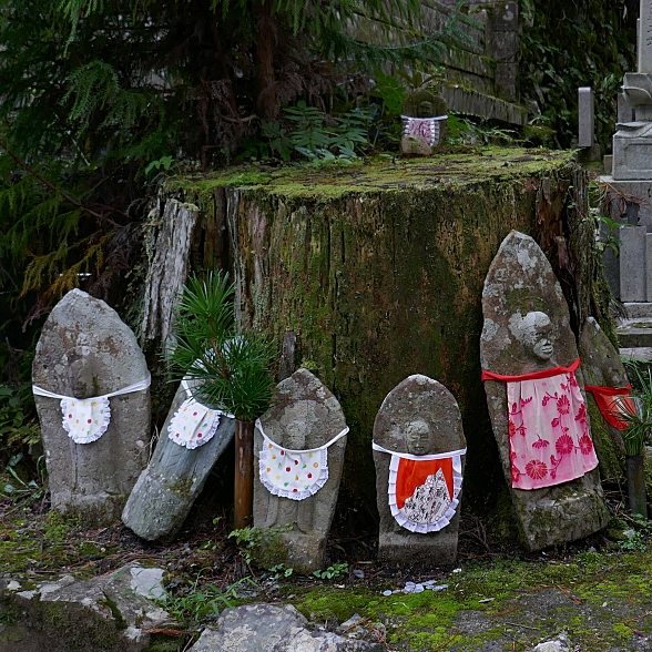 stele con Jizo in bassorilievo e bavaglini di stoffa colorata legati ad esse