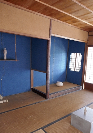 Interno casa tradizionale con alcova e tikonoma blu e tatami e muri marroni