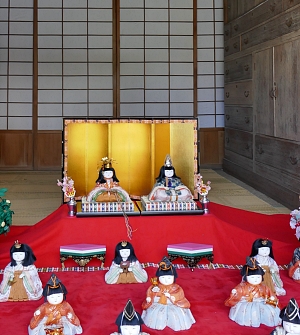 kimekomi hina su tappeto rosso e davanti a un paravento dorato