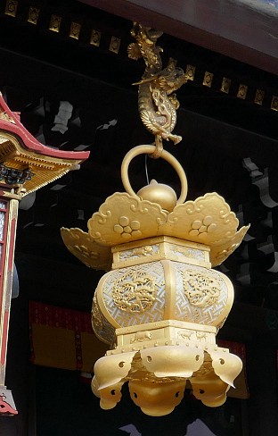 Lanterna gialla appesa alla coda del drago Kitano Tenmangu decorata con pino e ume